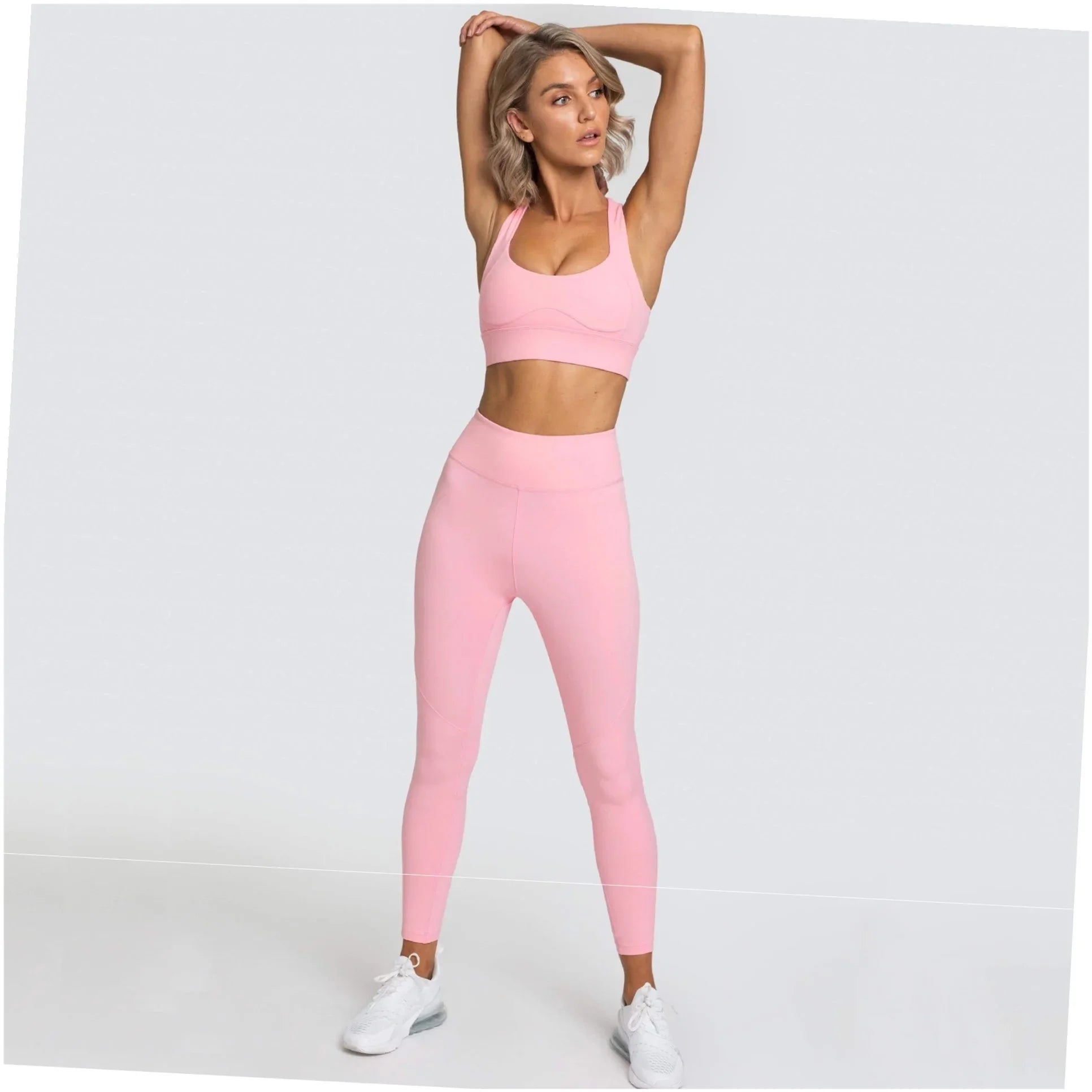 Soft pink athletic set with high-waisted leggings and supportive sports bra, styled for graceful movement.