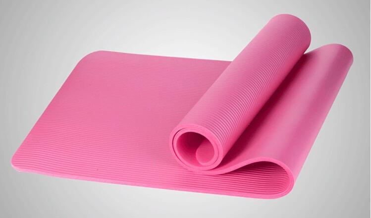 Soft pink yoga mat with textured grip, elegantly rolled for mindful movement and serene practice.