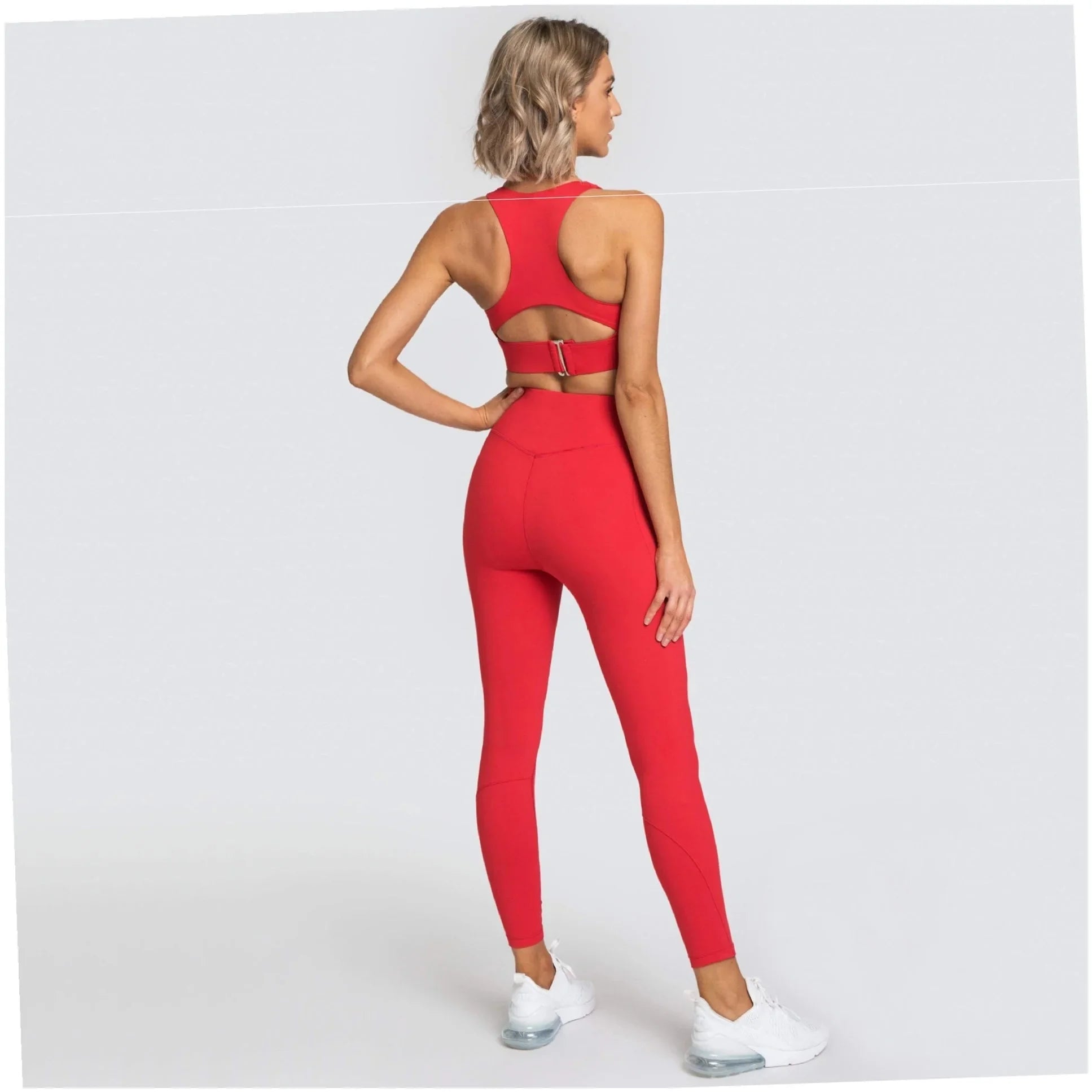 Red athletic set with open-back sports bra and high-waisted leggings, styled for active elegance.