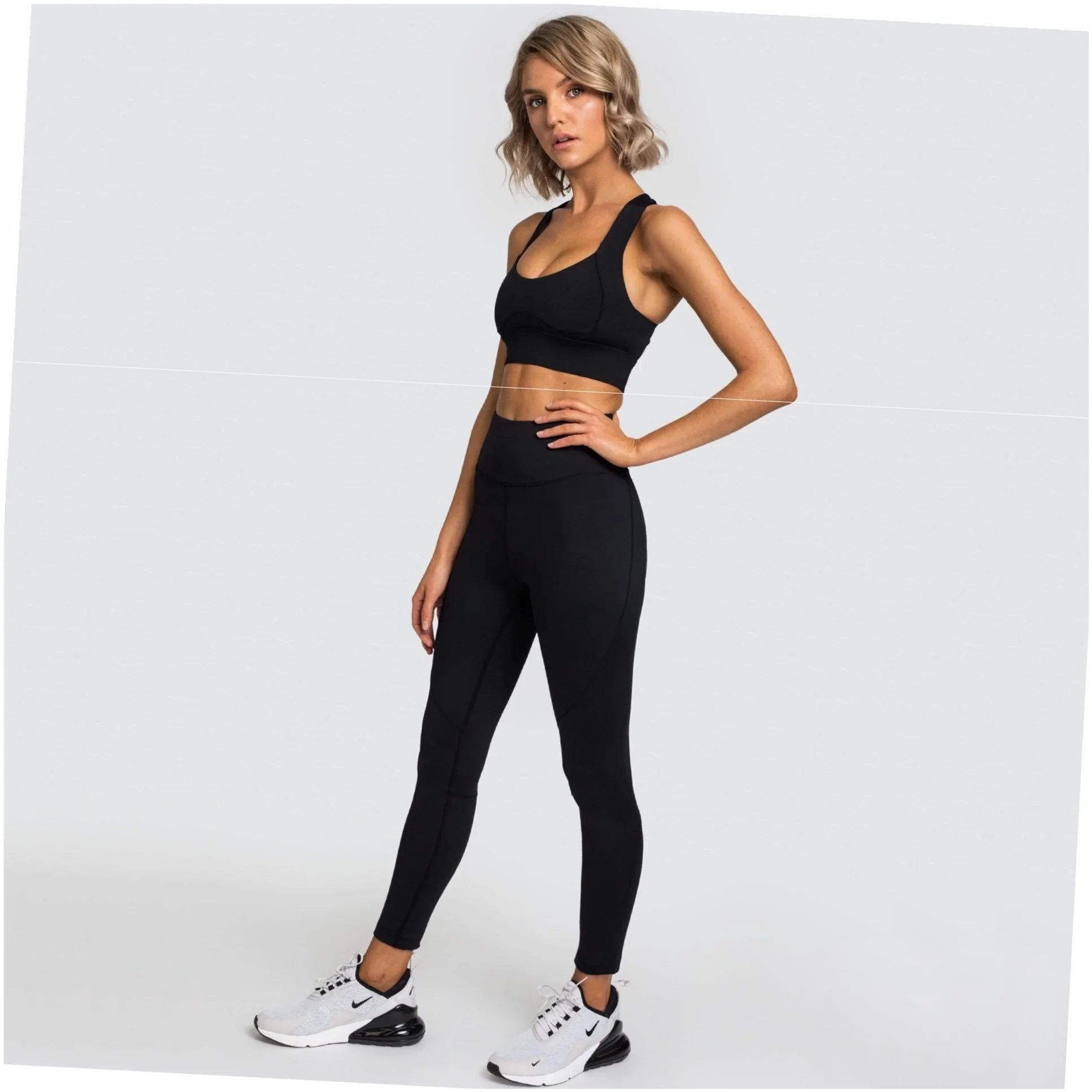 Woman in elegant black activewear set with high-waisted leggings and sports bra, styled for faith-inspired fitness